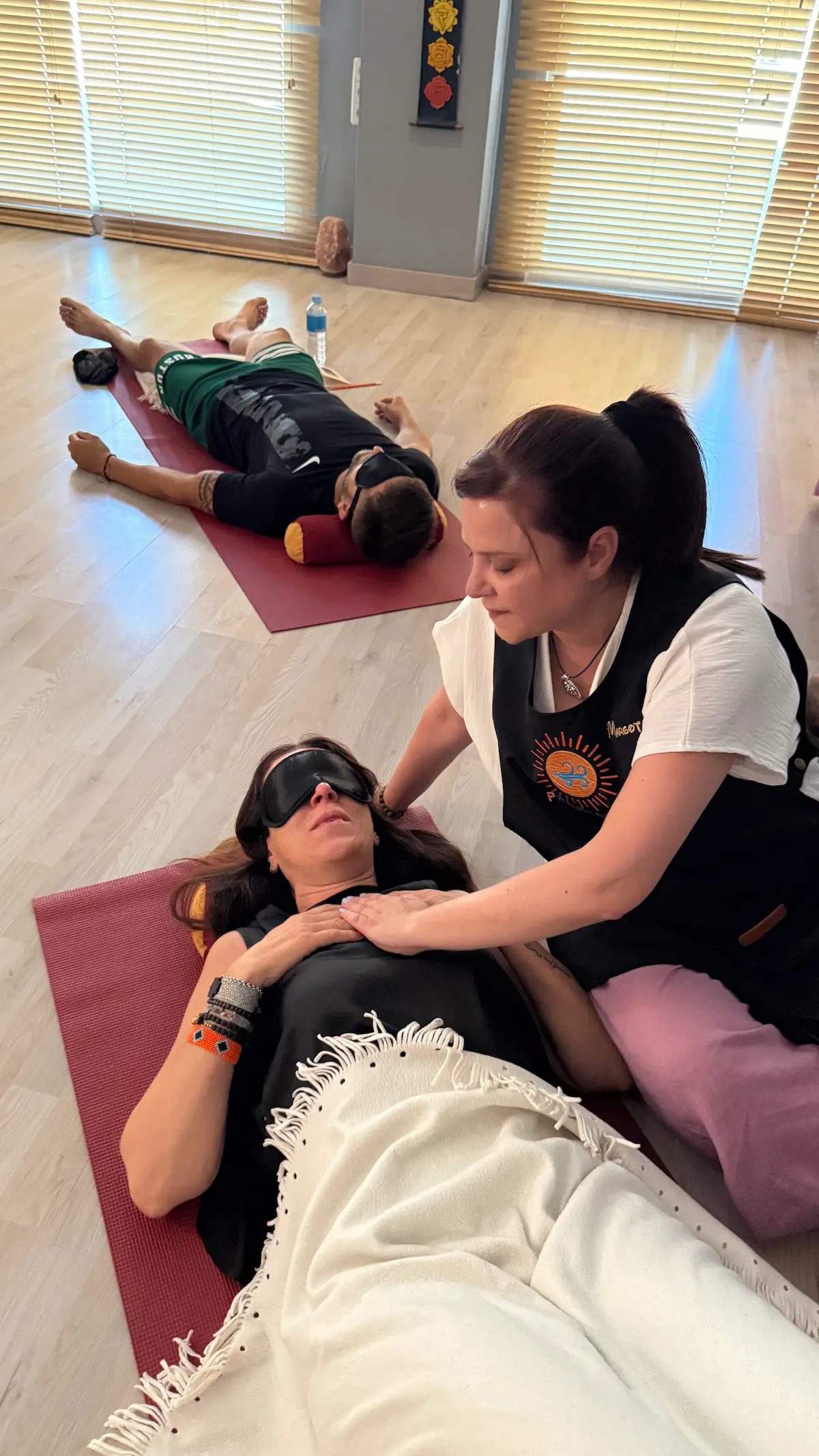 Facilitadora acompañando de cerca a una participante tumbada durante la sesión del taller